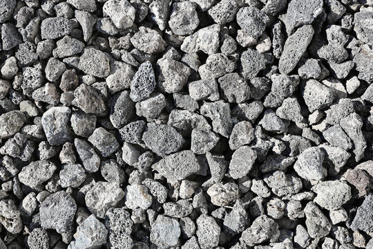 Gray gravel stone texture background. Crushed rock surface closeup. Rough aggregate pattern. Construction material detail. Natural stone ground. Industrial mineral texture. Abstract rocky backdrop.