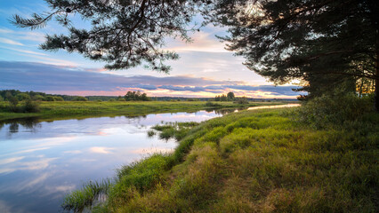 Morning sunrise landscape of foggy river with wet grass forest and sunrise sky