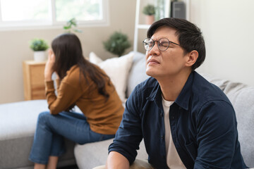 Family problem concept, Asian wife and husband sitting back to back in the living room at home have...