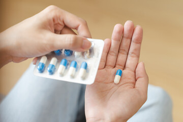 Healthcare Harmony: Close-Up Hands Holding Medication and Water Glass for Optimal Wellness,...