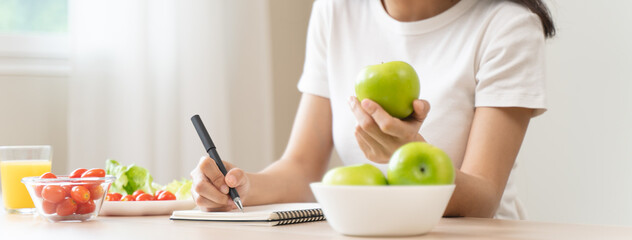 Wellbeing of health with good food control concept. Woman writing the meal note and plan to eat...