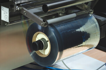 Automatic polyethylene plastic bag production machine with lighting effect. Close-up of the roller...