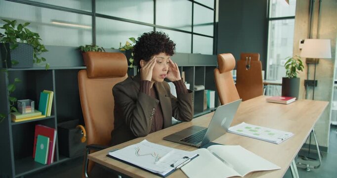 Executive under pressure preparing reports in cluttered office environment