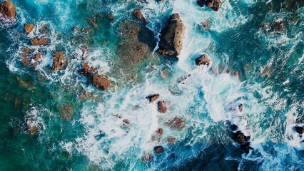 Aerial view of waves crashing on rocks
