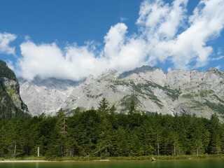 Majestic Watzmann East Face above K&ouml;nigssee, dramatic clouds, green shoreline. Copyspace.