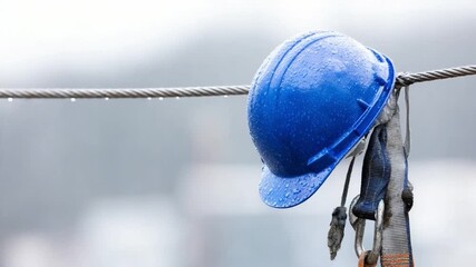 Safety First: A vibrant blue hard hat, hanging as a symbol of protection, epitomizes construction safety. This image is a tribute to the trades and the importance of workplace safety.