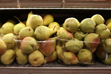 Display of Fresh Ripe Green Pears Packed in Clear Plastic Punnet Containers on a Supermarket Grocery Store Shelf