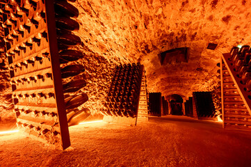 Riddling or remuage sediment to the bottle neckin deep underground caves on pupitre wooden racks, traditional method making champagne sparkling wine in Reims, Champagne, France