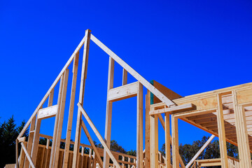 Obraz premium Workers build framework rafters beams of wooden house in construction site.