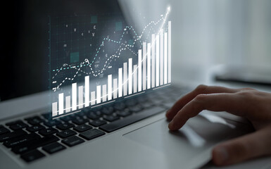 A hand interacts with a laptop, displaying dynamic data visualizations like graphs and charts. The scene symbolizes modern financial growth analysis and technology integration. Impute