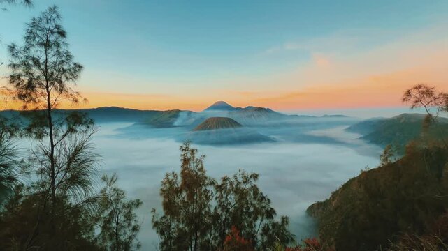 Eruption of the Bromo volcano during sunrise in the Bromo-Tengger-Semeru National Park, East Java, Indonesia. The Tengger volcanic caldera is in cloud and fog. Dawn. 4К