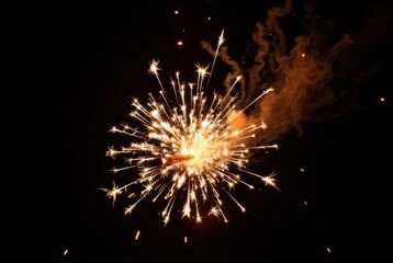 Fototapeta premium Ignited sparkler emits a dazzling burst of golden light and shimmering particles at night