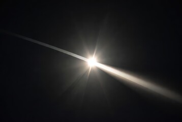 Powerful light beam with strong lens flare effect and radial rays on dark background