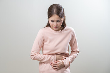 Obraz premium Flatulence asian young woman intolerance hand in stomach ache, suffer from food poisoning, abdominal pain and colon problem, gastritis or diarrhoea when at home. Patient belly, abdomen or inflammation