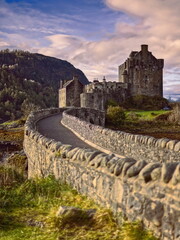 Eilean Donan tidal island-castle linked to the mainland by a stone footbridge, Beinn Fhada on Glenelg peninsula in the background. Dornie-Scotland-191