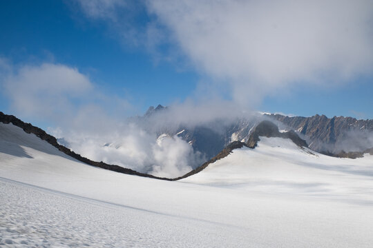 High alpine glacier plateau with mountain ridge and clouds