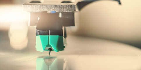Vinyl record player needle on spinning record surface macro close up. Analog music nostalgia retro sound, vintage audio technology, hobby and audiophile lifestyle.