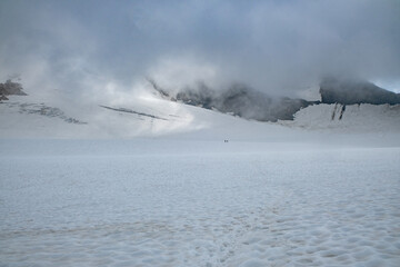 Alpinists crossing vast glacier in high alpine mountains