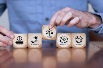 Code of conduct in business concept. Wooden blocks with code of conduct icons; code, integrity, honesty, respect, and ethics, the foundation of a strong corporate code of conduct. Corporate ethics. 