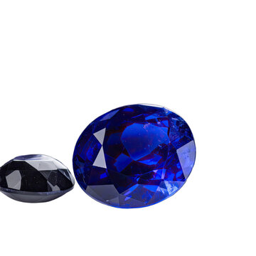 Two oval-cut gemstones, one vibrant blue sapphire and one dark cabochon, displayed against a black background.