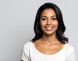 Smiling woman in white top against gray