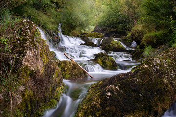 Cascades on Krupa river with mossy boulders, silky water in long exposure, calming scene