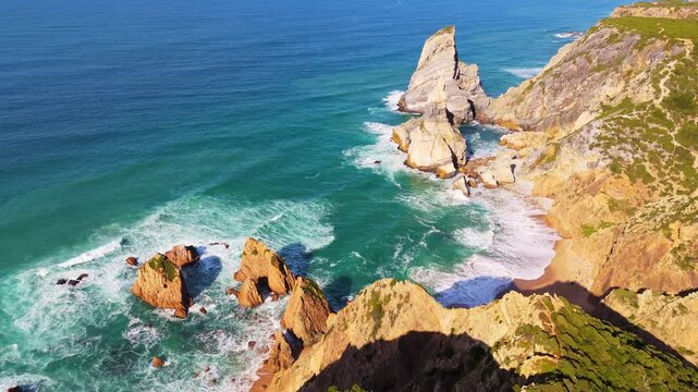 Cabo da Roca, Ursa Beach, Sea Stacks, Cliffs, Green Mountains and Atlantic Ocean on Sunny Day from Above. Aerial View. Portugal. Moving Backwards and Upwards
