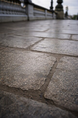 Obraz premium Low angle shot of wet cobblestones on Pont Alexandre III bridge.