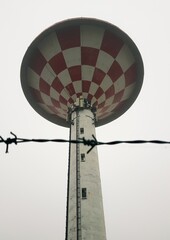 Water tower with barbed wire in a foggy day, closeup of photo