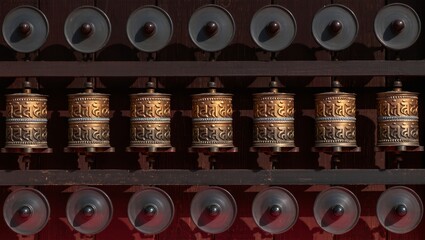 Beautifully crafted prayer wheels in a row, symbolizing spirituality and devotion