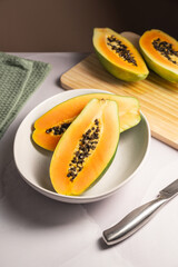 Papaya exotic fruit halves on plate. Healthy vegan food.