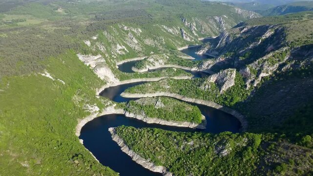 Aerial view of Uvac Canyon in Serbia. Showcasing the dramatic meanders of the Uvac River. Steep limestone cliffs surround the river, which twists and turns through the landscape. 