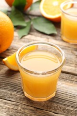 Fresh orange juice and fruits on wooden table, closeup