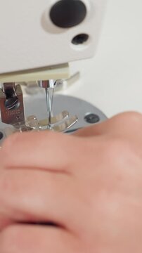 closeup marking seam beside needle and bobbin, hands tracing guideline with marker and aligning layers for prototype, careful measurement and test stitching, visible throat plate and bobbin thread,