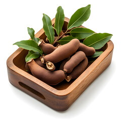 Fresh tamarind fruit pod with green leaf in wooden tray. raw natural tropical ingredient for healthy cooking
