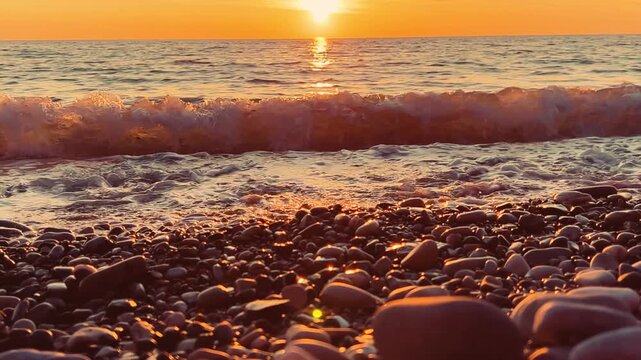 Orange sunset in Tuapse, sea waves with foam run to the shore. The Black Sea coast at sunset in the clouds. Pebble beach in the village of Agoy. The stormy sea in the evening. 4К