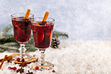 Mulled wine. Warm spiced beverage served in elegant glasses, garnished with cinnamon sticks and surrounded by festive decorations, creating cozy winter atmosphere perfect for holiday gatherings