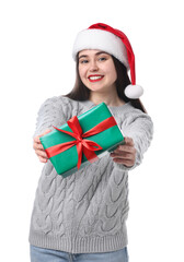 Beautiful woman in Santa hat with Christmas gift on white background