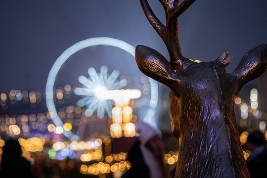 Jednorogi renifer spoglądający się na młyńskie koło na Jarmarku świątecznym 
