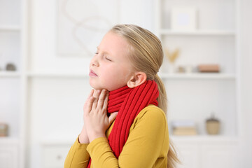Little girl suffering from sore throat at home. Cold symptom