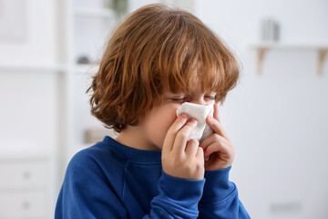 Little boy with runny nose at home. Cold symptom