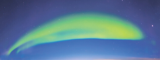 Bright neon green aurora arc stretching smoothly across a cobalt night sky, forming a perfect glowing bridge of light that hovers above the distant horizon like a celestial smile

