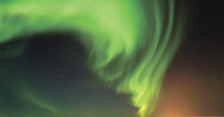 Spiraling crown of vivid green aurora borealis swirling over a dark polar horizon, sculpting...