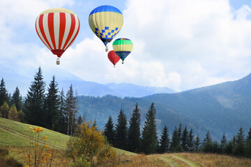 Fototapeta premium Colorful hot air balloons flying above mountains