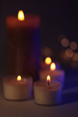Soft focus. blur Burning candles in dark. Evening, night Light and shadow brown black background. Minimalist still life.