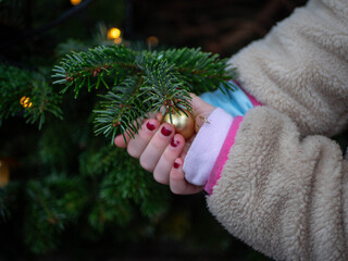 Child's hands holding a golden Christmas bauble 