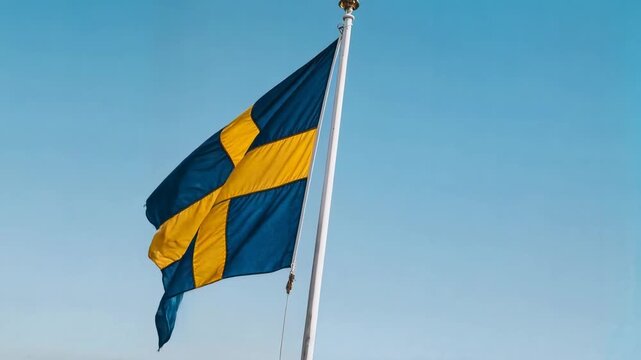 Swedish flag flutters on pole against clear blue sky expressing national pride identity and Scandinavian summer atmosphere