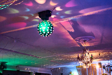Colorful lighting in a classic space, for parties and celebrations. Colored lights, decorations, flowers, reflections, etc. to illuminate and dance on the dance floor.