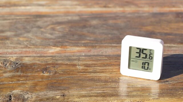 Digital thermometer displaying rising celsius degrees from 35 to 36. Concept of heatwave, climate change, and global warming