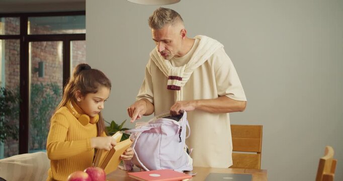 Family morning moment of packing and cheerful conversation at breakfast